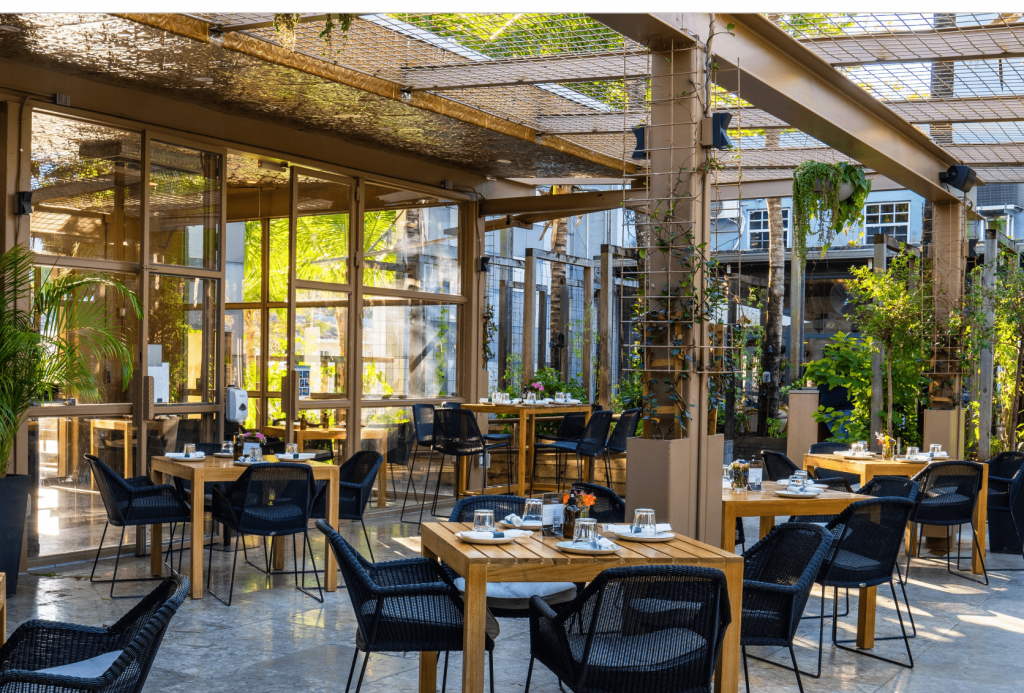 The inviting exterior of Ironside Pizza, a family-friendly Miami pizza restaurant. Ample outdoor seating with a warm and welcoming atmosphere for families Activar la compatibilidad con lectores de pantalla