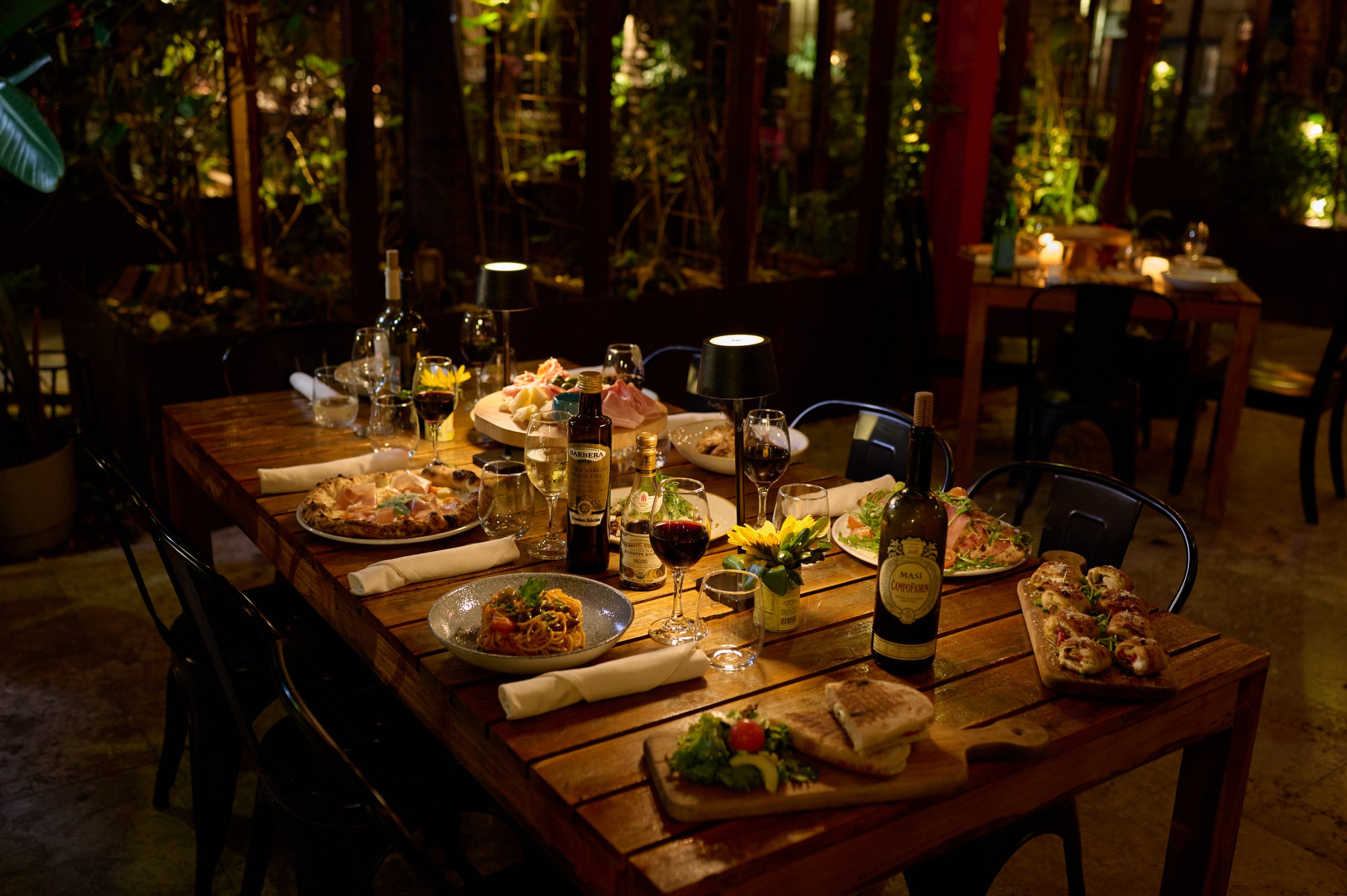 Ironside Pizza, a family restaurant with a wooden table topped with lots of delicious Italian food.